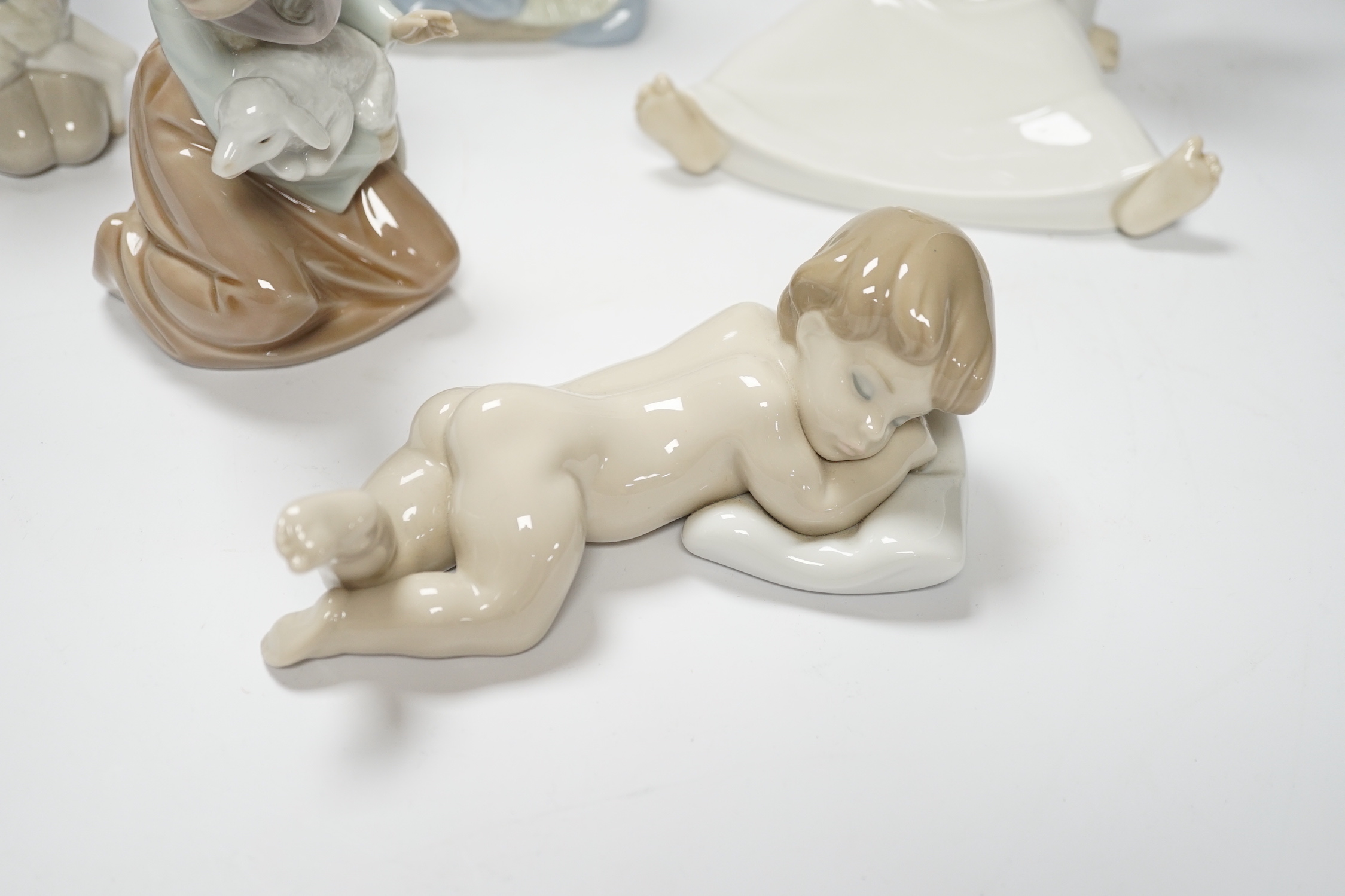Five Lladro figures; two angelic, two nativity, one of a sleeping child and another of a girl with a lamb, all in boxed, largest 17cm high